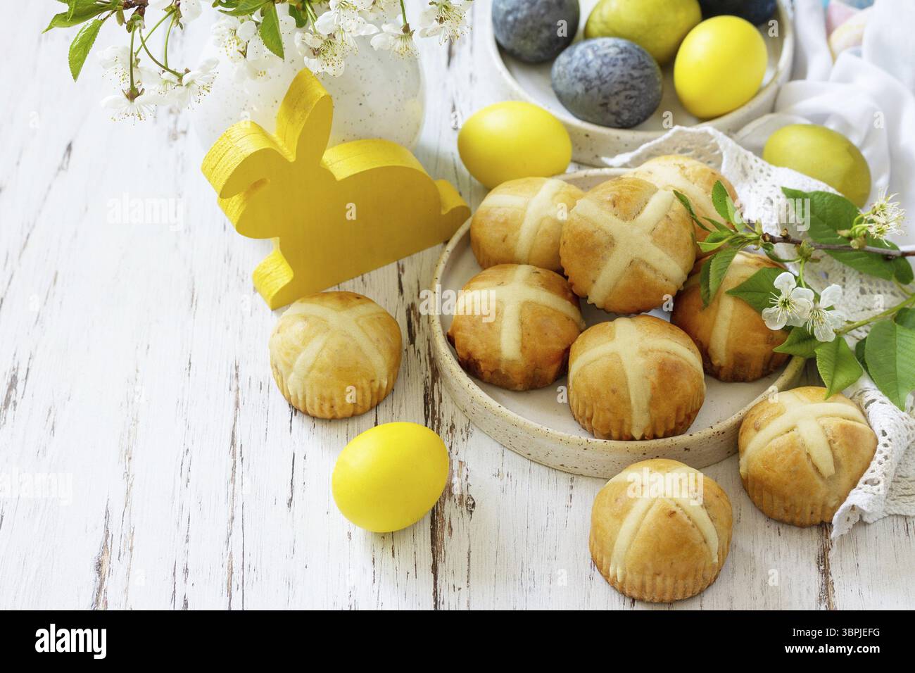 Felice Pasqua cibo festivo concetto. Tradizionale croci pasquali caldi fatti in casa con uva passa e uova pasquali colorate naturali su un tavolo rustico. Copia spa Foto Stock Felice Pasqua cibo festivo concetto. Tradizionale croci pasquali caldi fatti in casa con uva passa e uova pasquali colorate naturali su un tavolo rustico. Copia spa Foto Stock