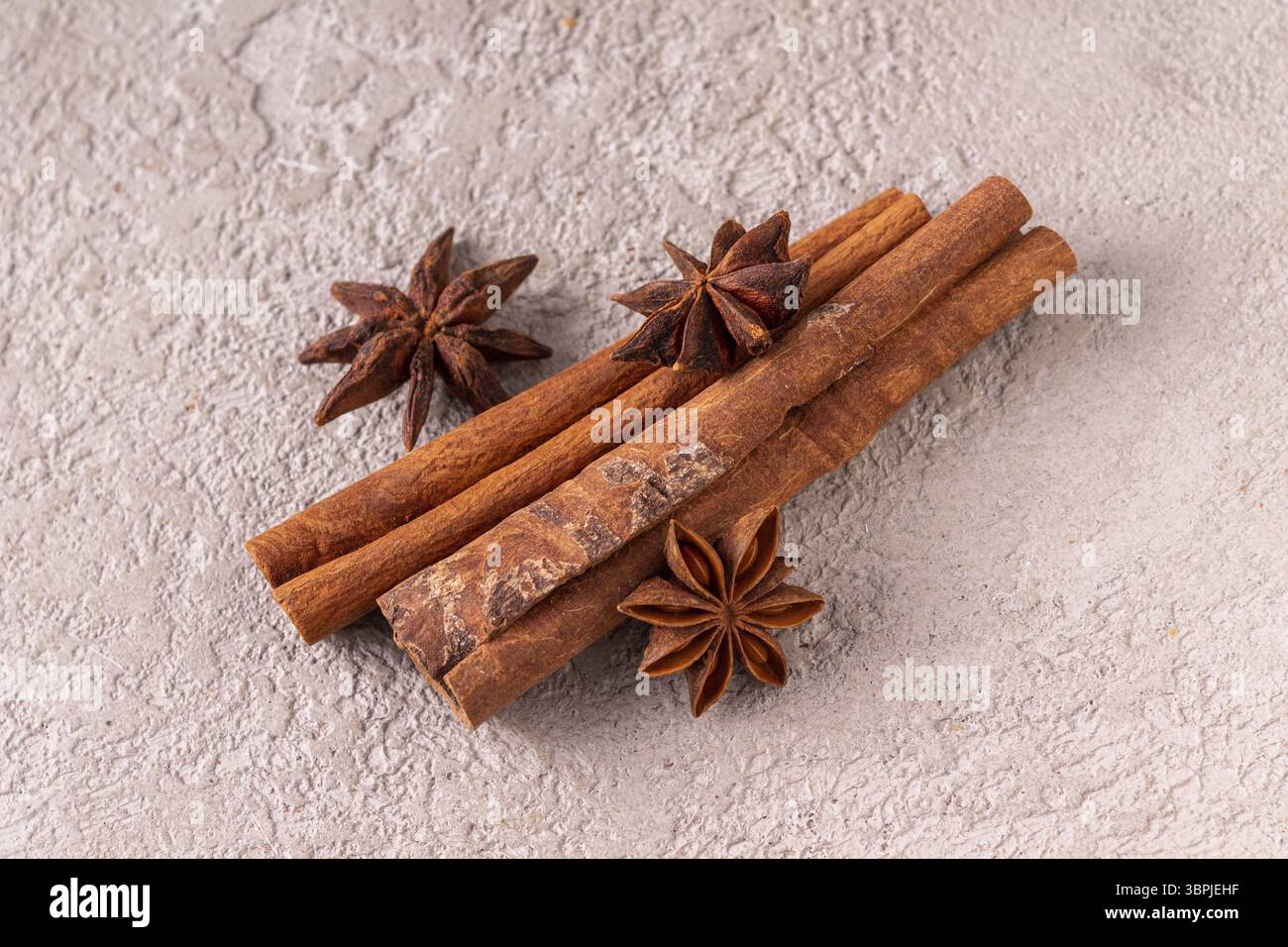 Bastoncini di cannella e anice stellato su intonaco grigio Foto Stock