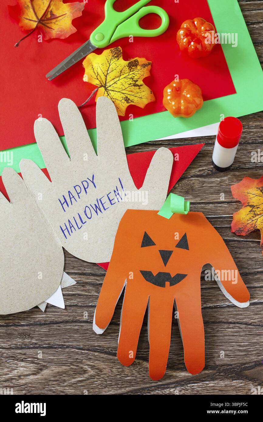 Biglietto d'auguri con zucca felice Halloween su un tavolo di legno. Progetto creativo per bambini, artigianato, artigianato per bambini Foto Stock