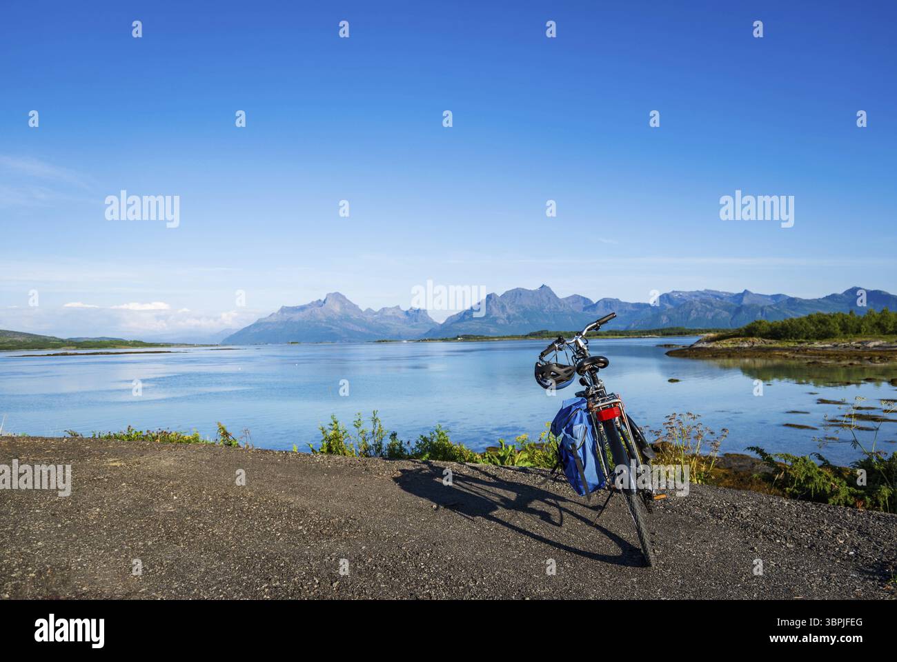 Foto di concetto di Bikepacking con bicicletta da turismo con un bellissimo paesaggio in estate con mare e montagne nel nord della Norvegia, Scandinavia Foto Stock