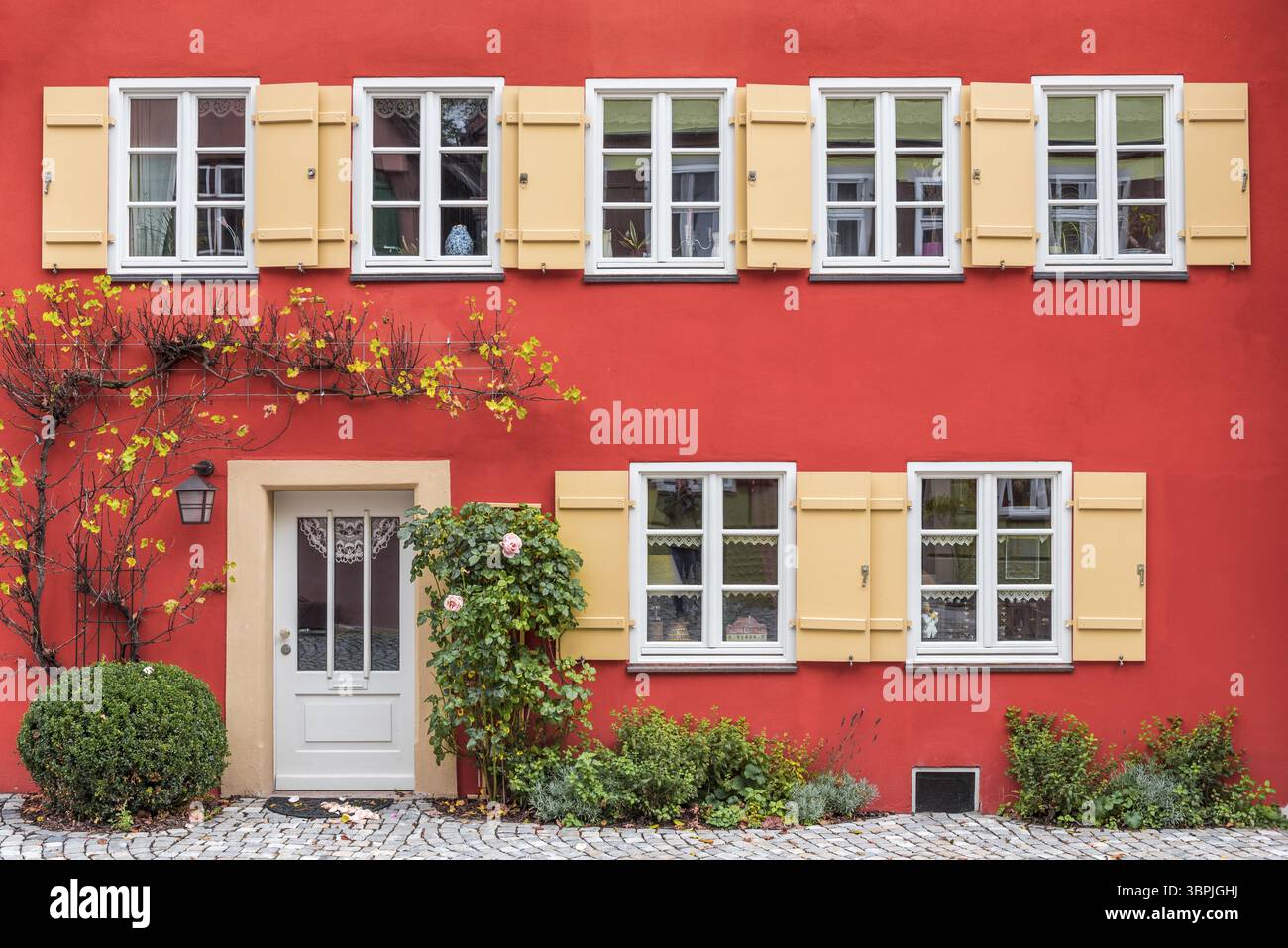 La facciata rossa di un vecchio edificio residenziale con finestre e ingresso, Dinkelsbuehl, Germania, Europa Foto Stock