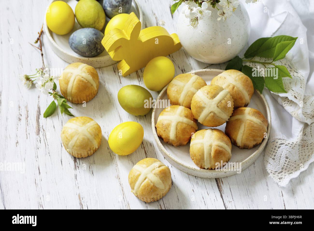 Felice Pasqua cibo festivo concetto. Tradizionale croci pasquali caldi fatti in casa con uva passa e uova pasquali colorate naturali su un tavolo rustico. Copia spa Foto Stock Felice Pasqua cibo festivo concetto. Tradizionale croci pasquali caldi fatti in casa con uva passa e uova pasquali colorate naturali su un tavolo rustico. Copia spa Foto Stock