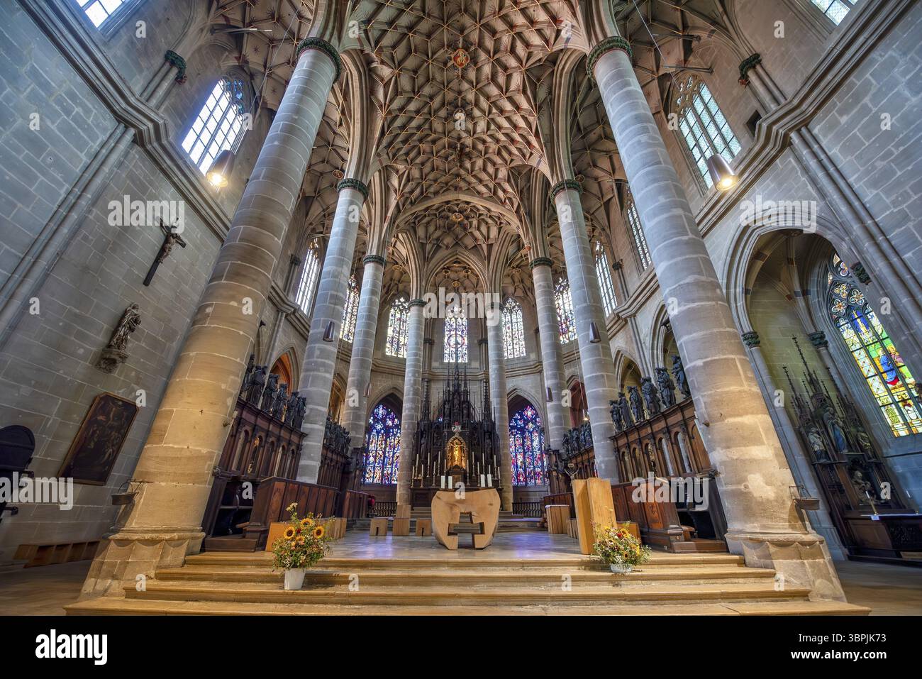 Vista interna dell'Heilig-Kreuz-Muenster a Schwaebisch Gmuend con la sua volta a rete, colonne, altare e vetrate colorate Foto Stock