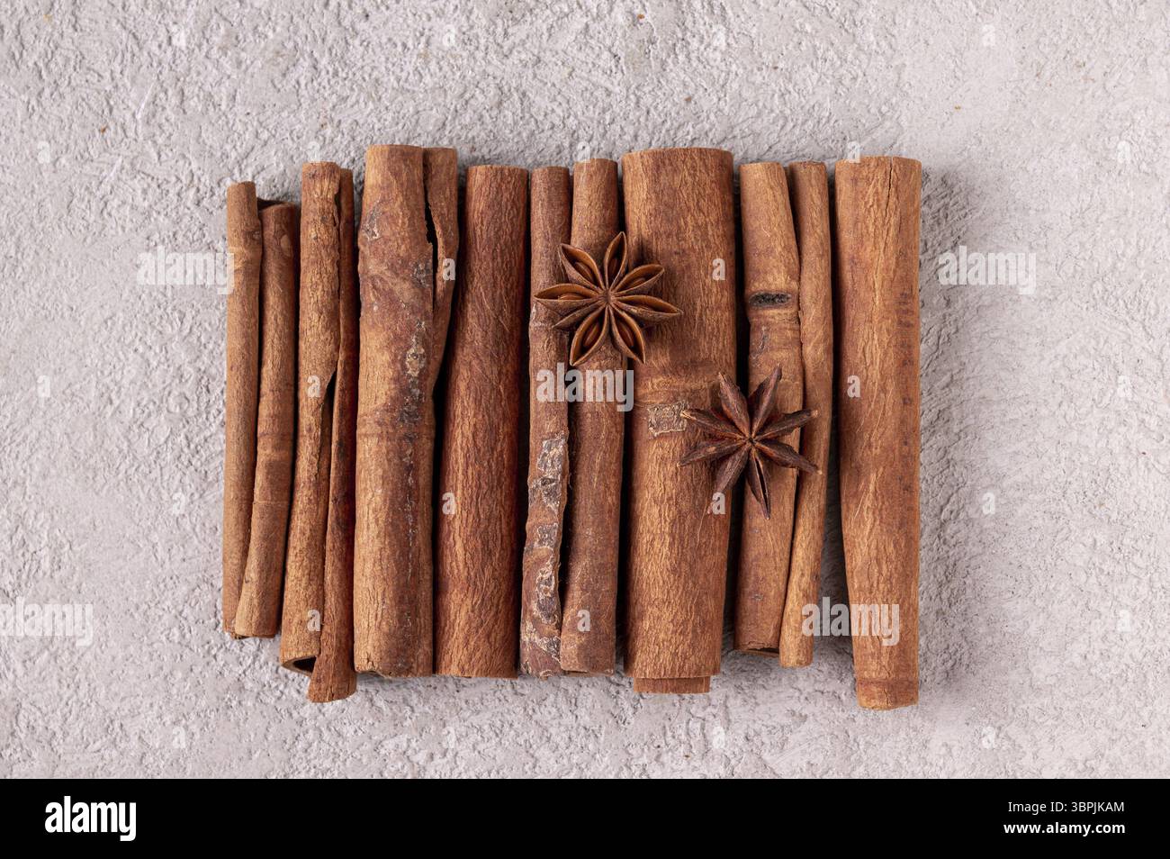 Bastoncini di cannella e anice stellato su intonaco grigio Foto Stock