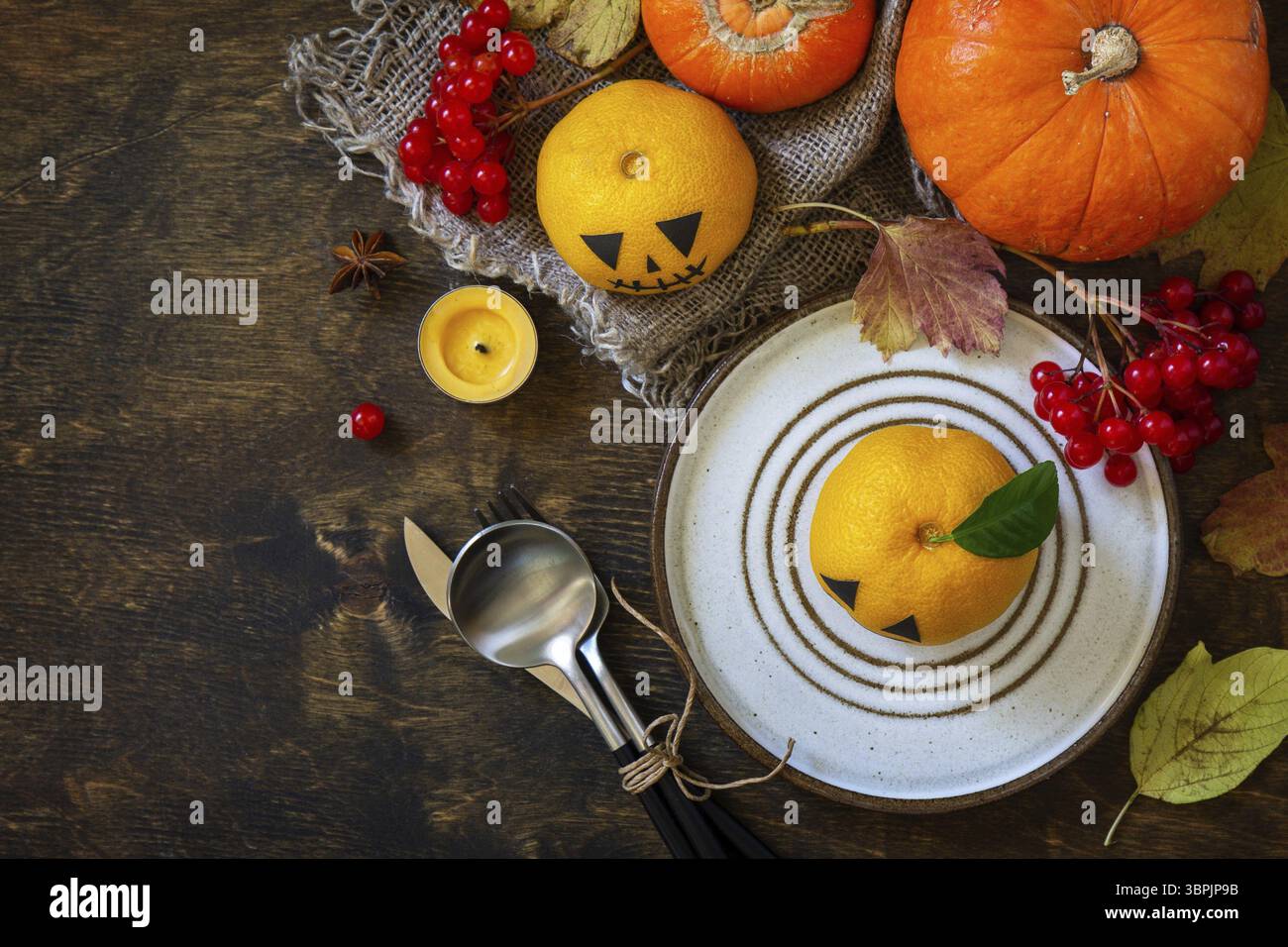 Festa decorativa di Halloween. Tavolo in legno di Halloween con zucche e mandarini. Sfondo piatto della vista superiore. Copia spazio Foto Stock