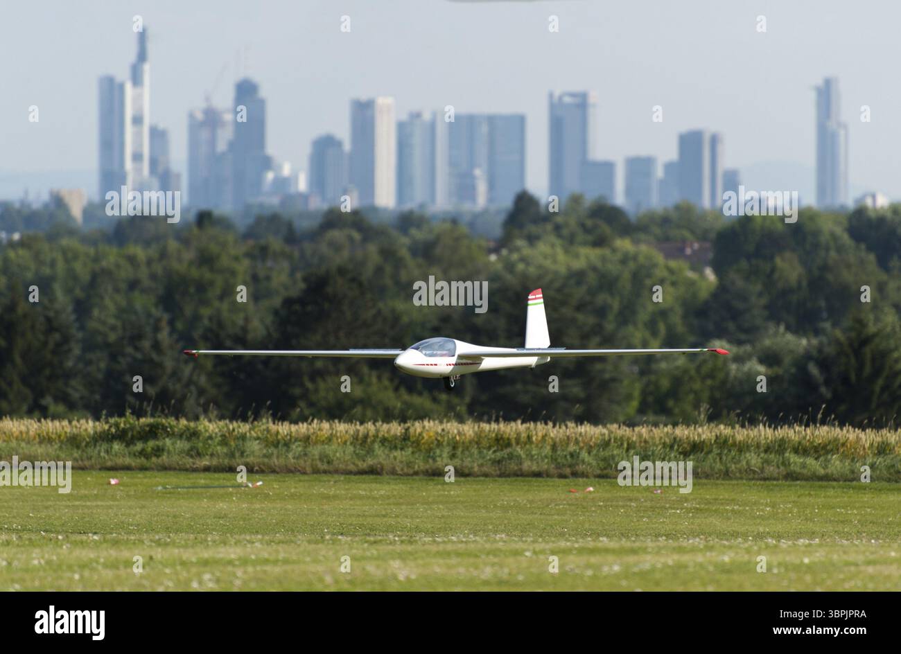 Un aliante che si avvicina di fronte allo sfondo sfocato dello skyline di Francoforte sul meno, Bad Homburg vor der Hoehe, Germania, Europa Foto Stock