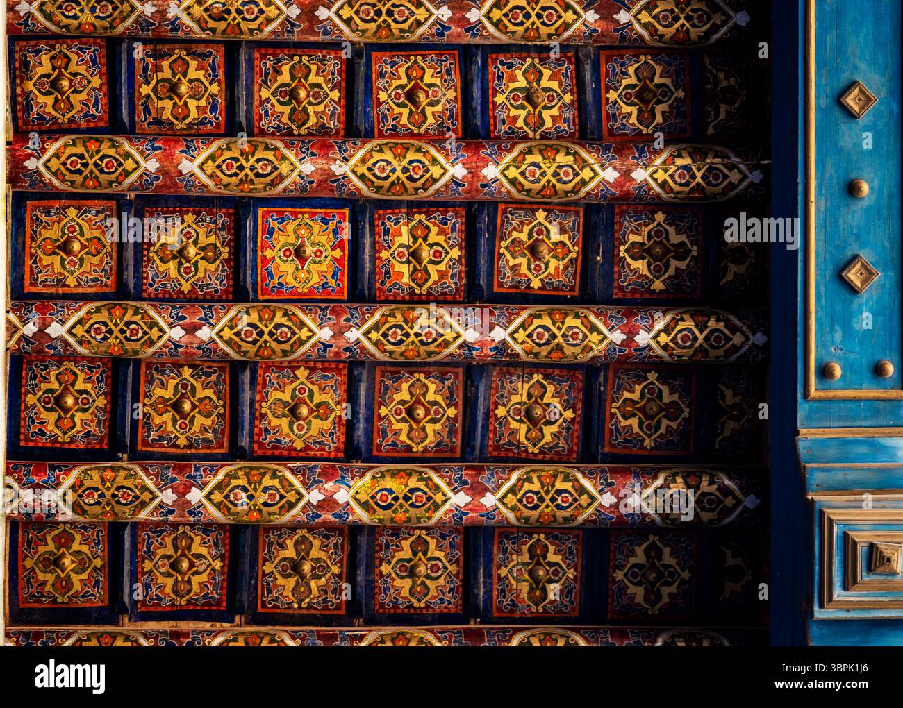 Un soffitto vibrante decorato con intricati motivi geometrici e colorate decorazioni floreali, che mettono in risalto la tradizionale maestria artigianale. I colori ricchi includono Foto Stock