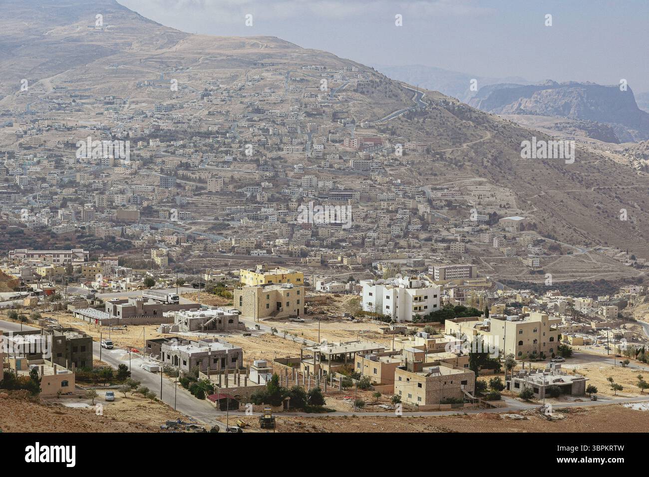 La moderna città di Wadi Musa, in Giordania, vista da una collina che domina l'arido paesaggio montano Foto Stock