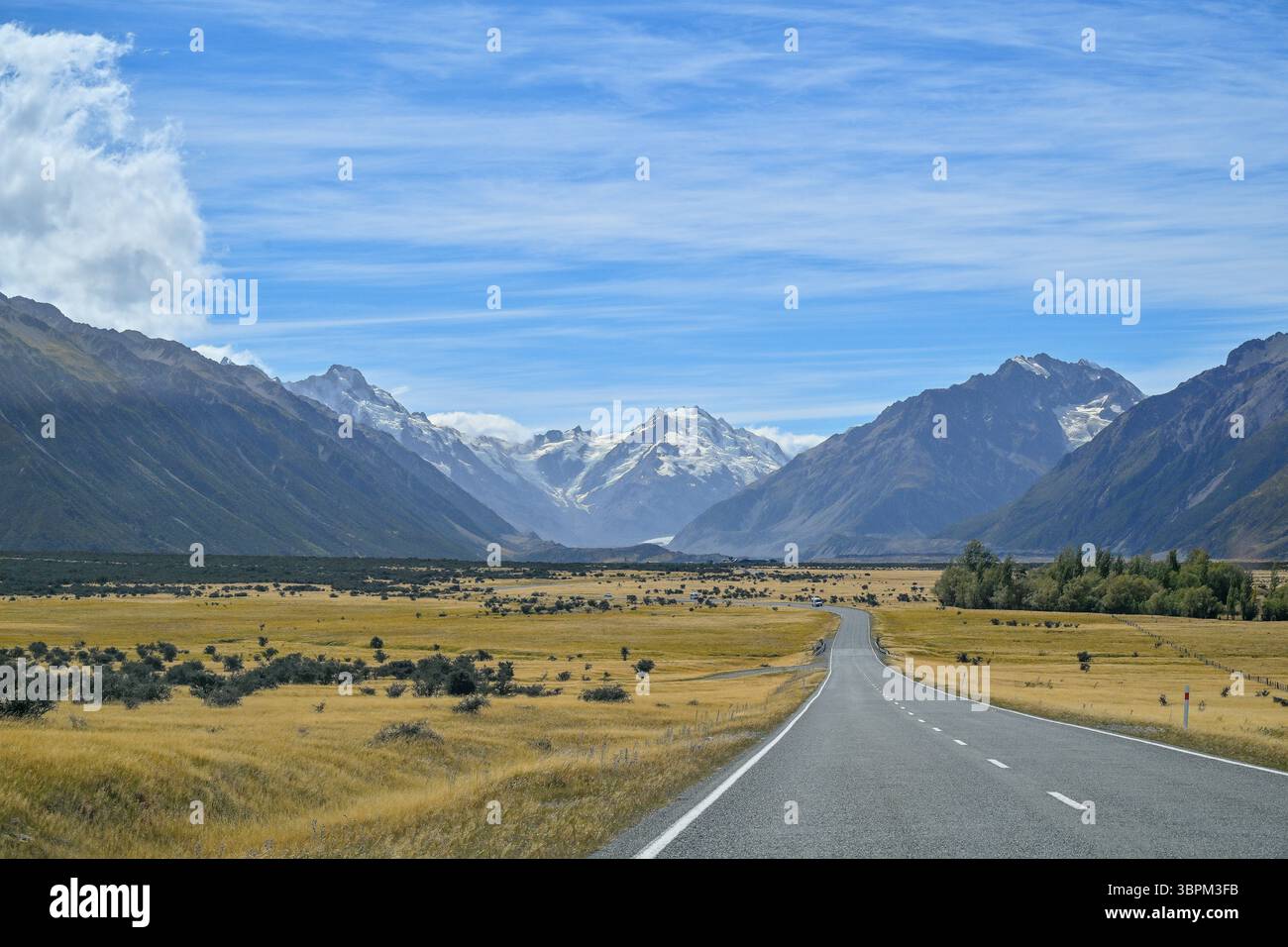 Strada rettilinea che conduce verso montagne innevate nel bacino di Mackenzie, Canterbury, South Island, nuova Zelanda Foto Stock