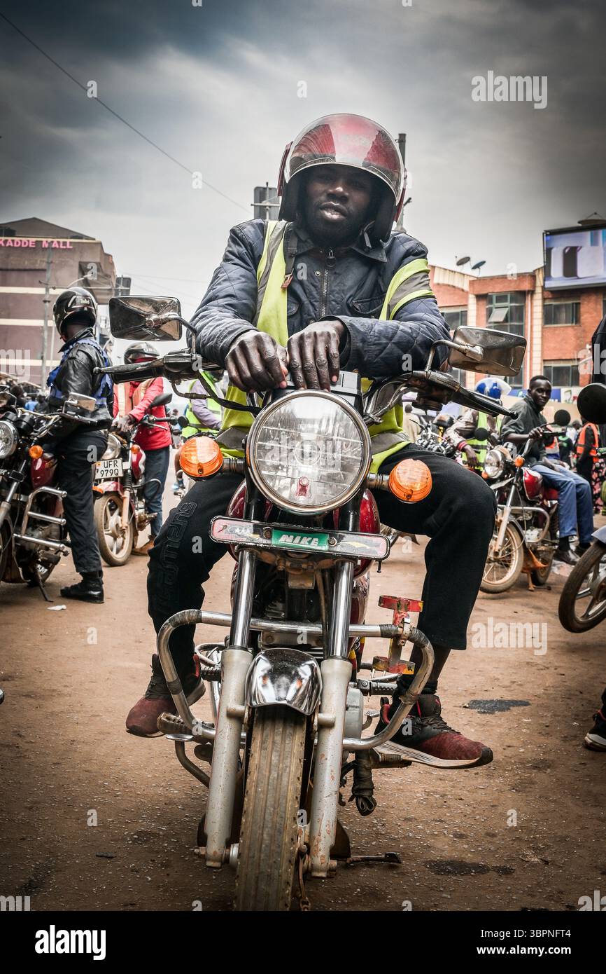 Boda boda motociclista taxi in attesa per le strade di Kampala, Uganda Foto Stock