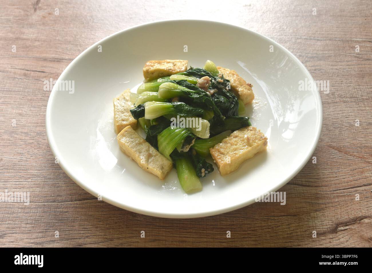 Mescolare il cavolo cinese fritto con fetta di tofu e tagliare il maiale in salsa di soia sul piatto Foto Stock