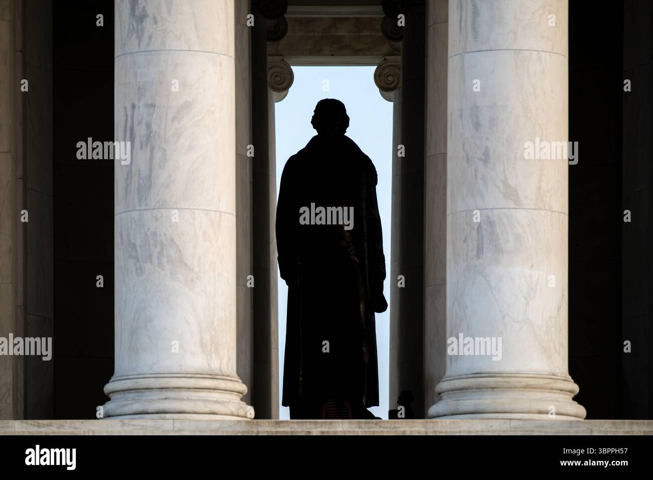 WASHINGTON DC - la statua di bronzo di Thomas Jefferson si trova all'interno del Jefferson Memorial, visto attraverso le colonne iconiche del monumento. La statua di 5,8 metri, creata dallo scultore Rudulph Evans, raffigura il terzo presidente degli Stati Uniti e autore principale della dichiarazione di indipendenza. Il memoriale, completato nel 1943, è stato progettato dall'architetto John Russell Pope in stile neoclassico con un colonnato circolare di colonne ioniche. Il monumento si trova sul bacino delle maree e funge da uno dei più riconoscibili memoriali presidenziali di Washington. La statua stessa fu installata nel 1947, quattro y Foto Stock