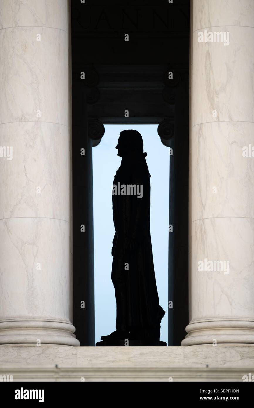 WASHINGTON DC - la statua di bronzo di Thomas Jefferson si trova all'interno del Jefferson Memorial, visto attraverso le colonne iconiche del monumento. La statua di 5,8 metri, creata dallo scultore Rudulph Evans, raffigura il terzo presidente degli Stati Uniti e autore principale della dichiarazione di indipendenza. Il memoriale, completato nel 1943, è stato progettato dall'architetto John Russell Pope in stile neoclassico con un colonnato circolare di colonne ioniche. Il monumento si trova sul bacino delle maree e funge da uno dei più riconoscibili memoriali presidenziali di Washington. La statua stessa fu installata nel 1947, quattro y Foto Stock