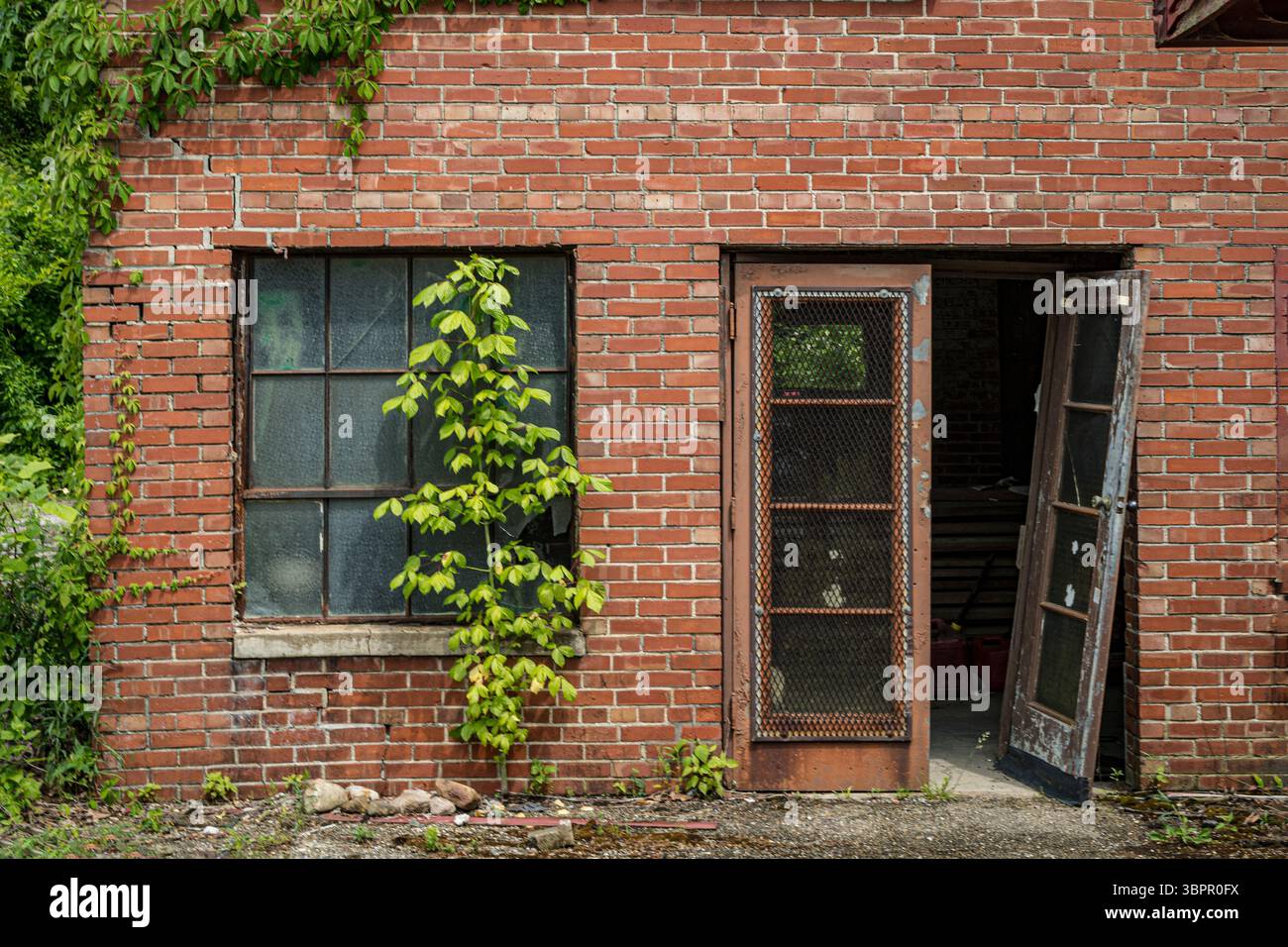 Porta e finestra rotte sovradimensionate all'esterno di un edificio abbandonato in mattoni, Indiana USA Foto Stock