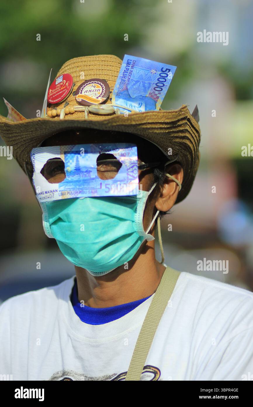 Gli attivisti anti-corruzione coprono i loro occhi con un pezzo di denaro come forma di protesta contro la corruzione dilagante. Foto Stock