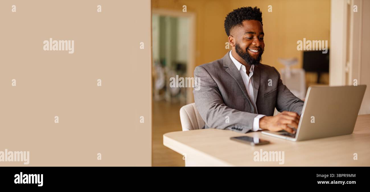 Ritratto di un professionista di sesso maschile sicuro che analizza il rapporto su un computer portatile mentre lavora in un ufficio moderno Foto Stock