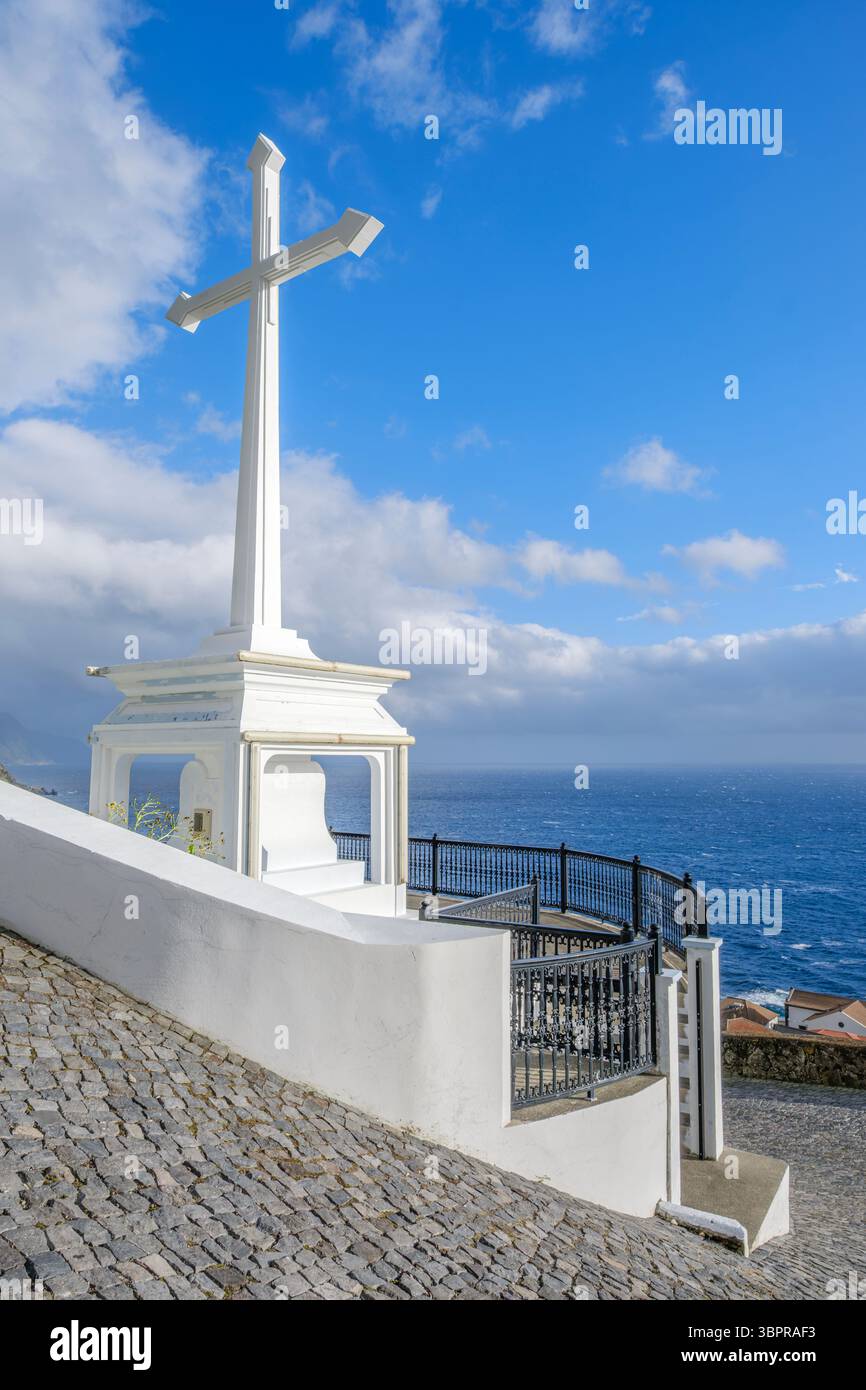 Monumento di White Cross affacciato sull'Oceano Atlantico nell'isola di Sao Jorge nelle Azzorre. Monumento religioso portoghese, punto panoramico costiero, sentiero acciottolato, drammaturgo Foto Stock