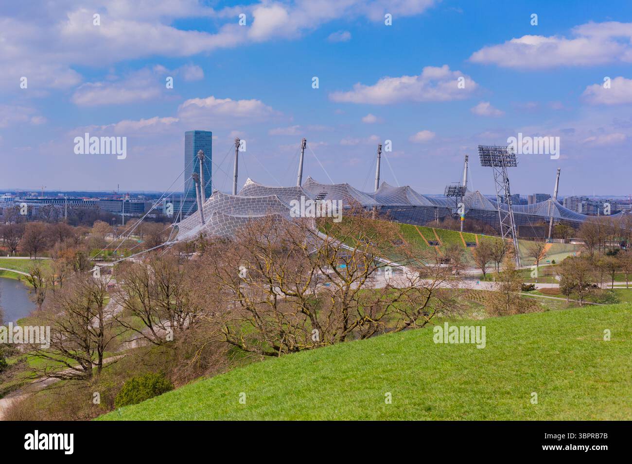 Monaco di Baviera, Germania: 2 aprile 2025: Una vista panoramica dell'Olympiapark di Monaco con lussureggianti prati verdi, alberi e la caratteristica architettura delle Olimpiadi Foto Stock