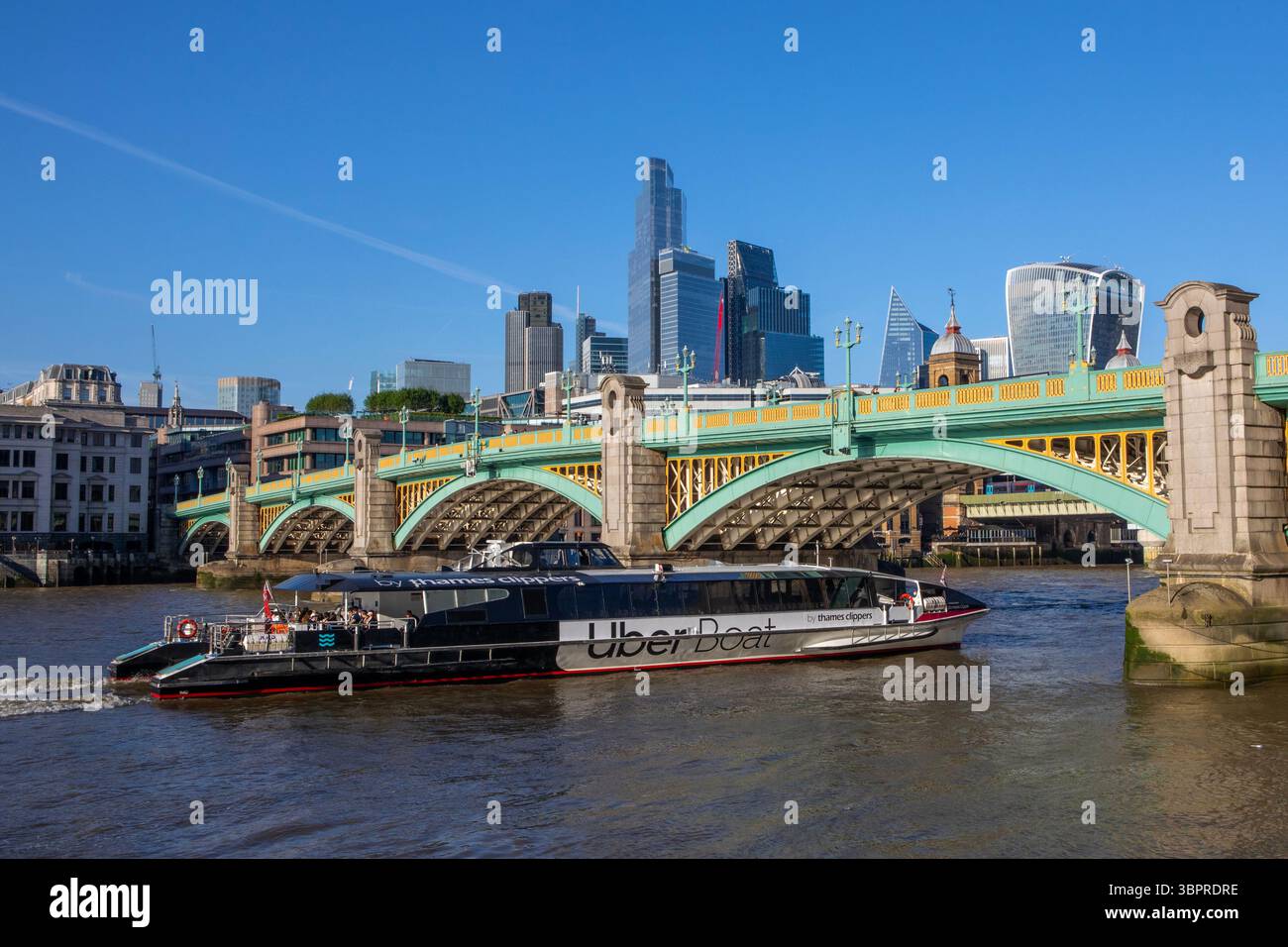 Londra, Regno Unito - 29 aprile 2025: Un Uber Boat passa sotto lo storico Southwark Bridge a Londra, Regno Unito. Foto Stock