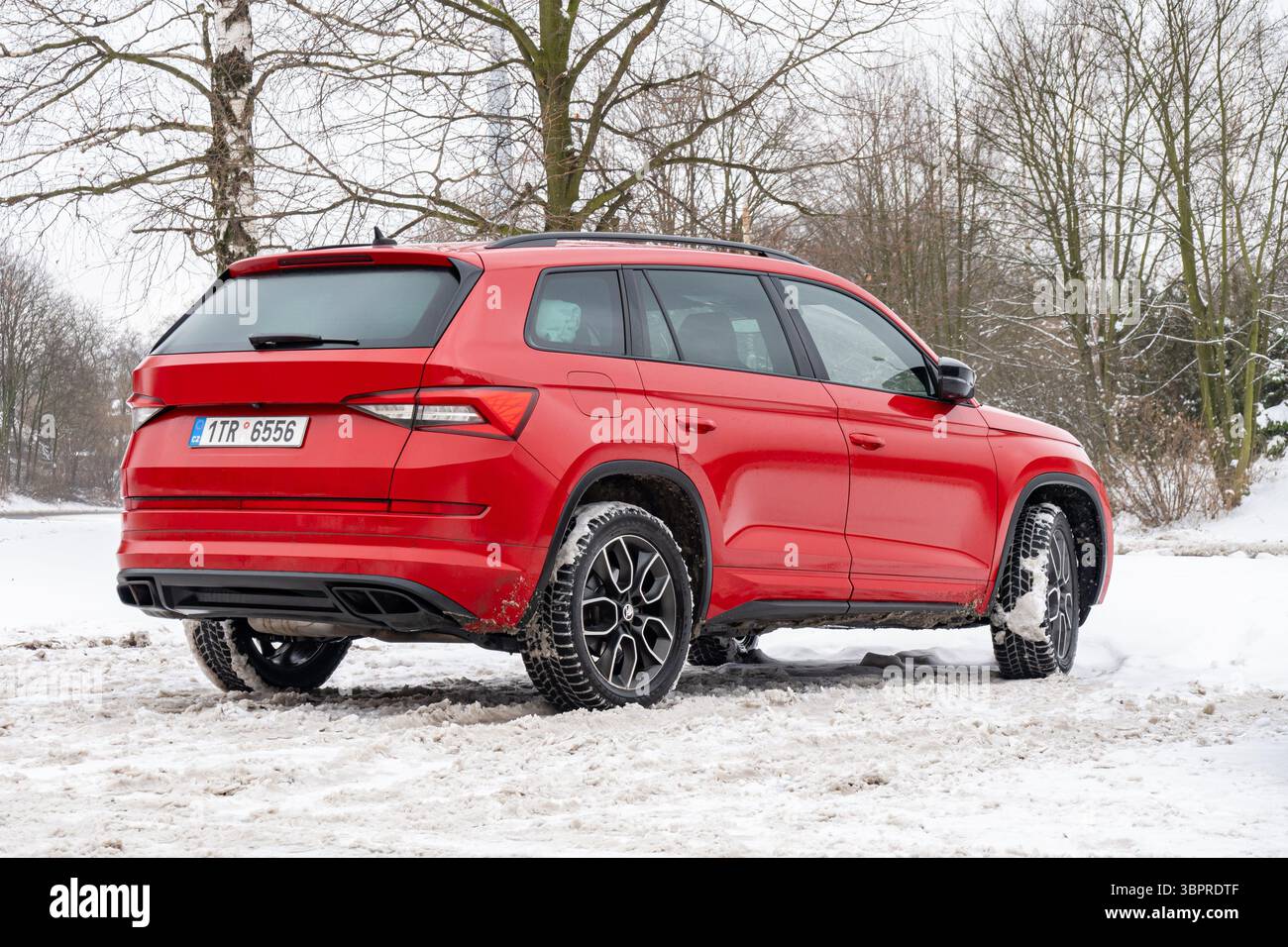 Havirov, Repubblica Ceca - 12 dicembre 2024: SUV rosso ceco Skoda Kodiaq RS parcheggiato vicino a forst in inverno innevato Foto Stock