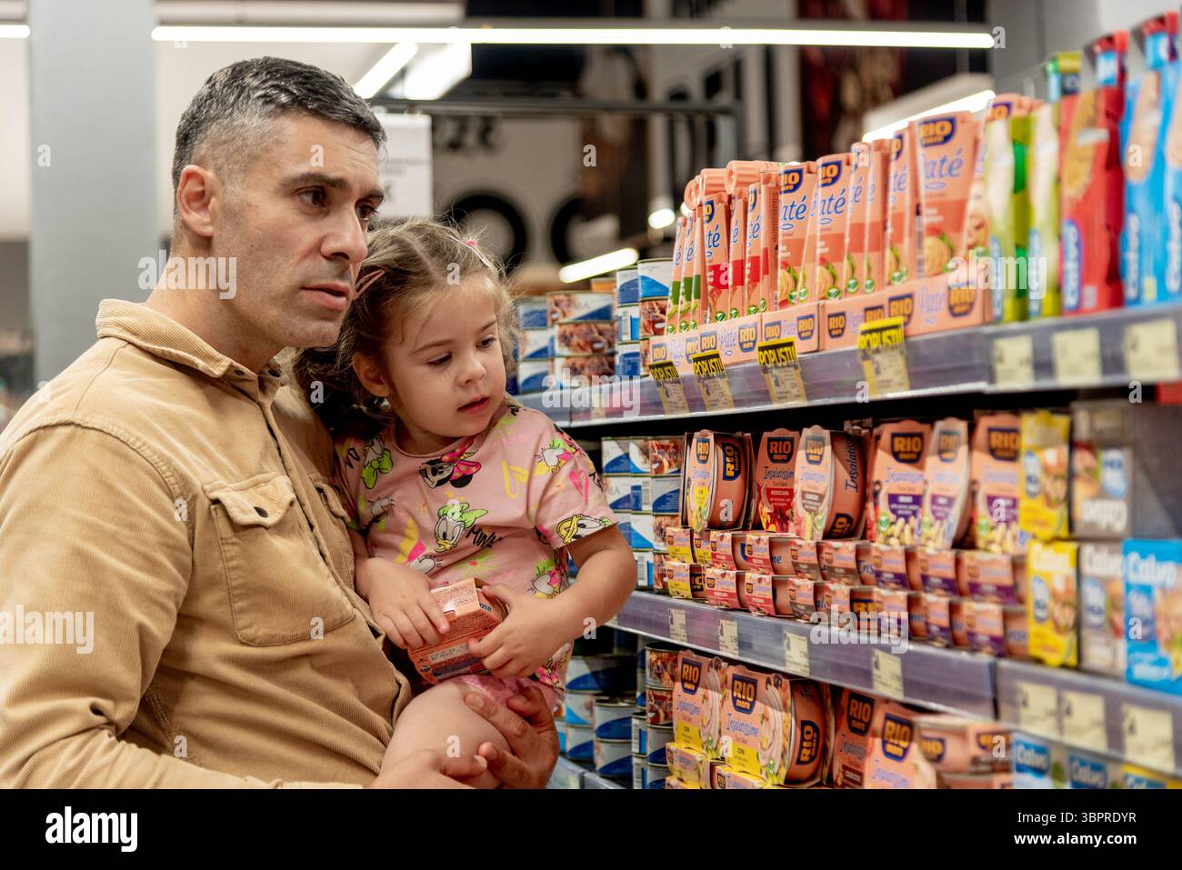 Bar, Montenegro, 17 maggio 2025, famiglia padre e figlia scelgono prodotti nel supermercato nel reparto conserve e salse Foto Stock