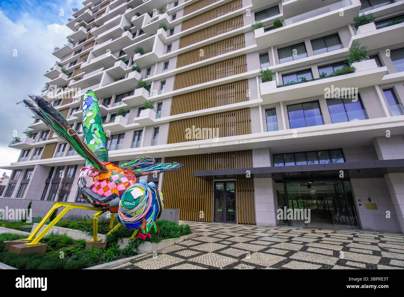 Sintra, Portogallo - 8 marzo 2025: Una scultura dai colori vivaci di una libellula, costruita interamente con materiali di scarto riciclati, si erge in evidenza Foto Stock