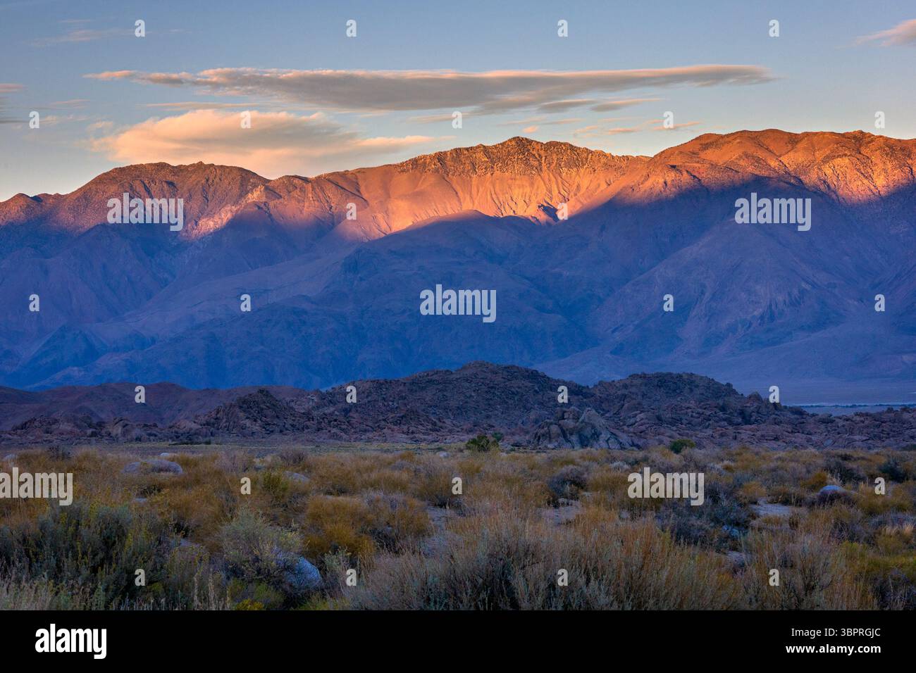 La luce del sole proietta un caldo bagliore sull'aspro paesaggio delle Alabama Hills Foto Stock