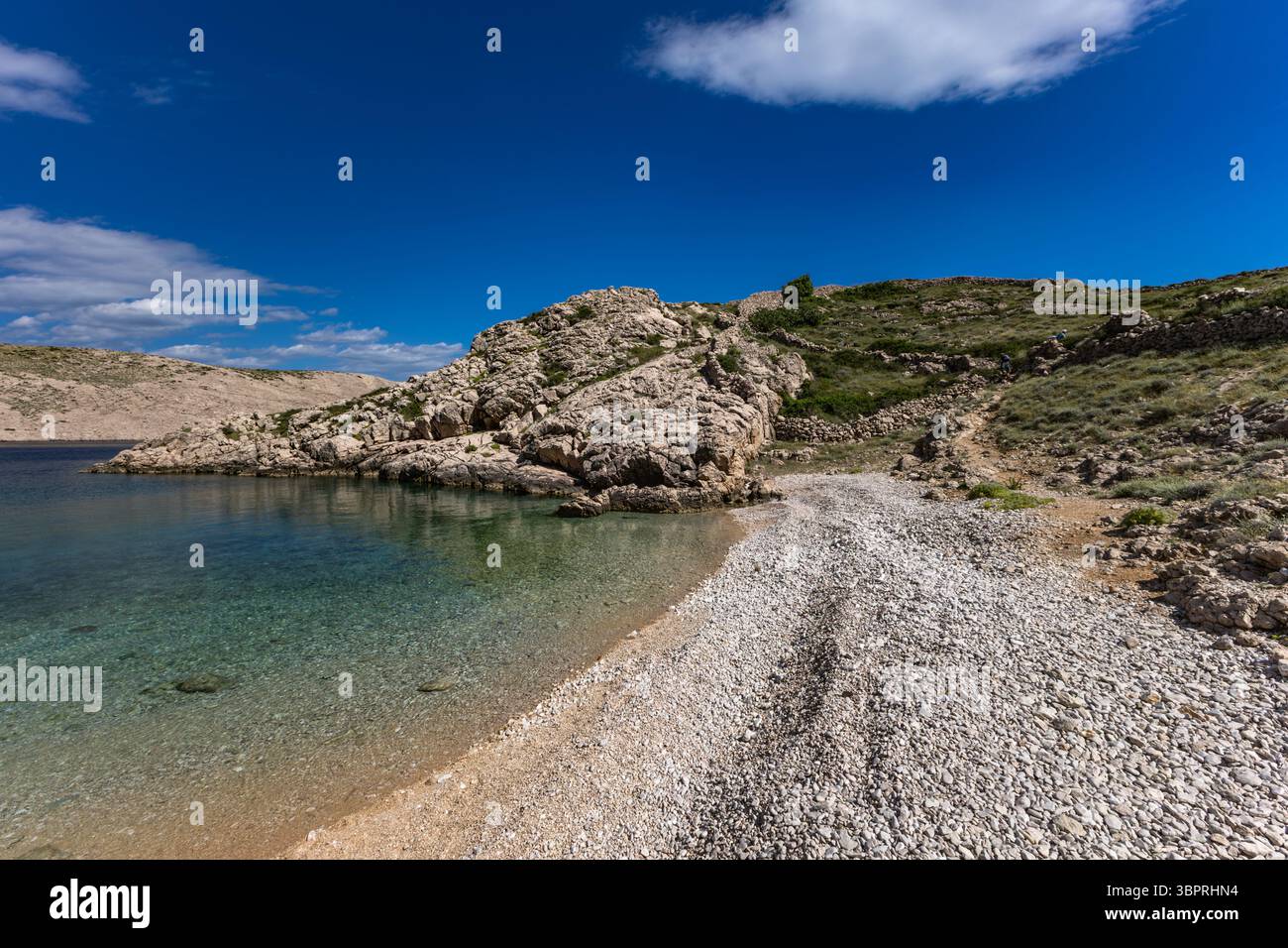 La pittoresca baia e la spiaggia di ghiaia di Gnjilova sull'isola DI KRK, una spiaggia sul sentiero turistico da Vela Luka a Baška Foto Stock