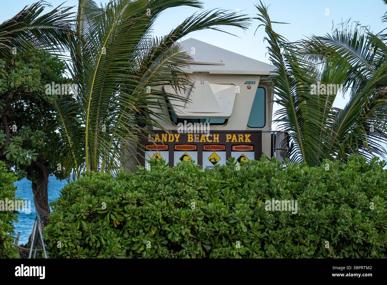 La torre del bagnino, illuminata dal sole, si erge tranquillamente sopra il Sand Beach Park, Honolulu Hawaii Foto Stock