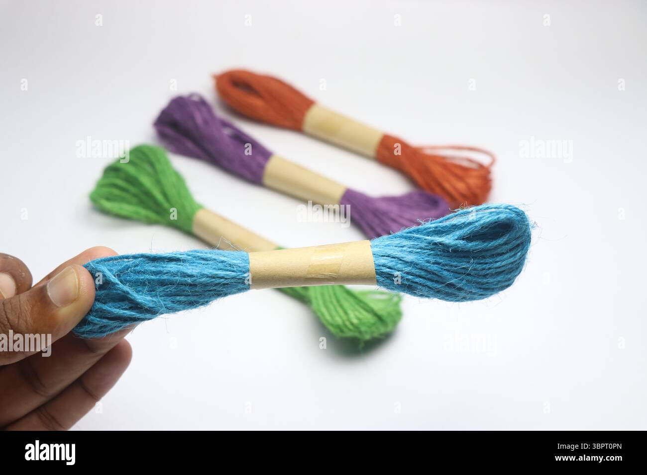 Filo di iuta naturale di diversi colori su sfondo bianco. Fili di iuta multicolore Foto Stock