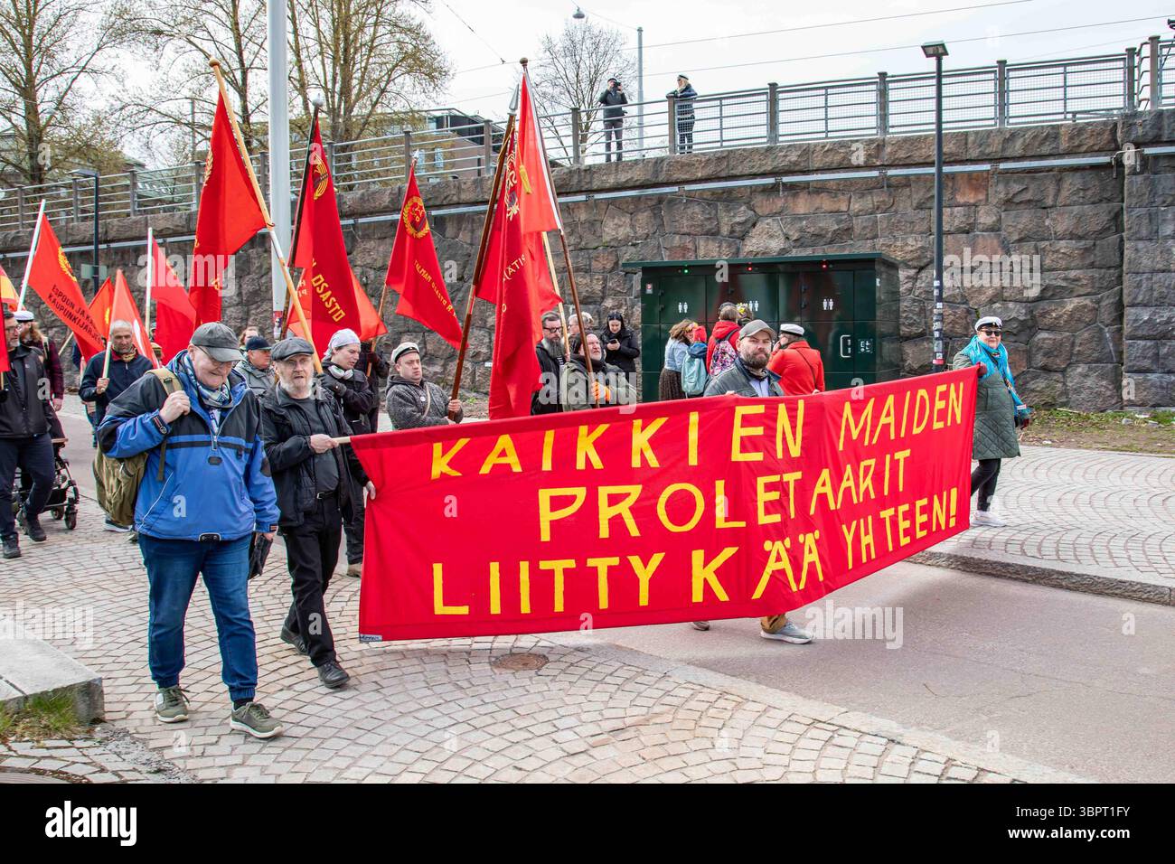 Kaikkien proletaarit liittykä yhteen! Comunisti con bandiere rosse e striscione al raduno del giorno di maggio a Helsinki, Finlandia. Foto Stock