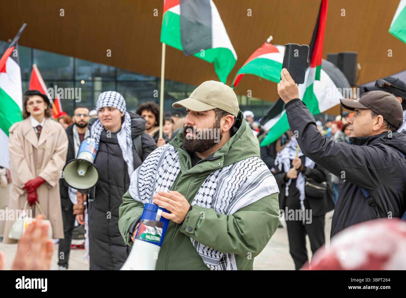 Dimostratore pro-Palestina con megafono in piazza Kansalaistori durante la dimostrazione del giorno di maggio a Helsinki, Finlandia Foto Stock