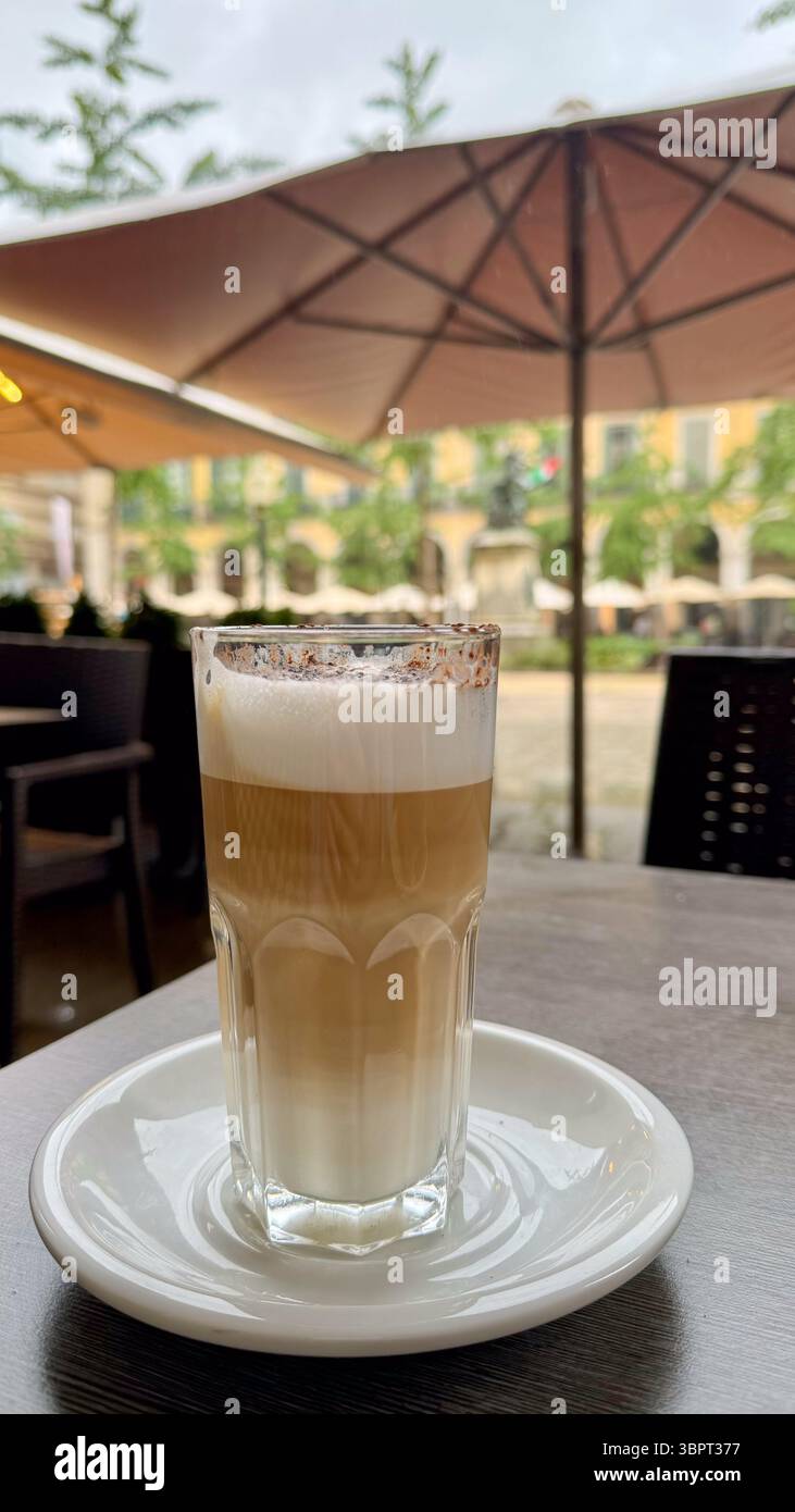 Bicchiere di caffè freddo servito in un caffè estivo all'aperto. Bevanda rinfrescante con ghiaccio in una giornata soleggiata, stile di vita urbano e concetto stagionale. Foto Stock
