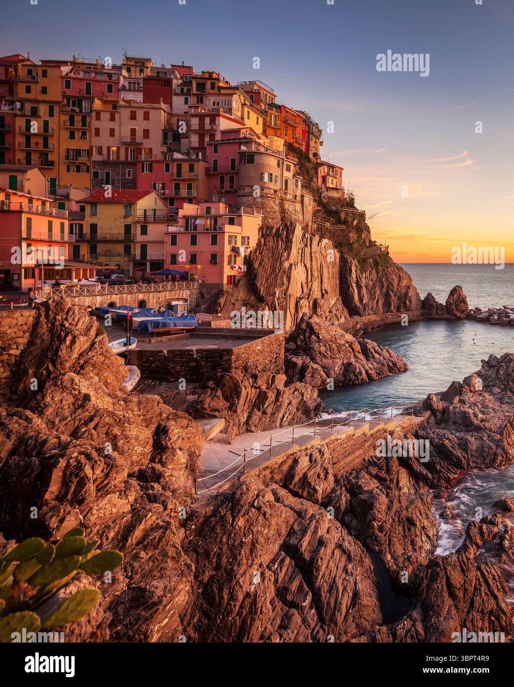 Tramonto sul bellissimo villaggio di pescatori di Manarola sulle rocce del Parco Nazionale delle cinque Terre, regione Liguria, Italia, Europa. Foto Stock