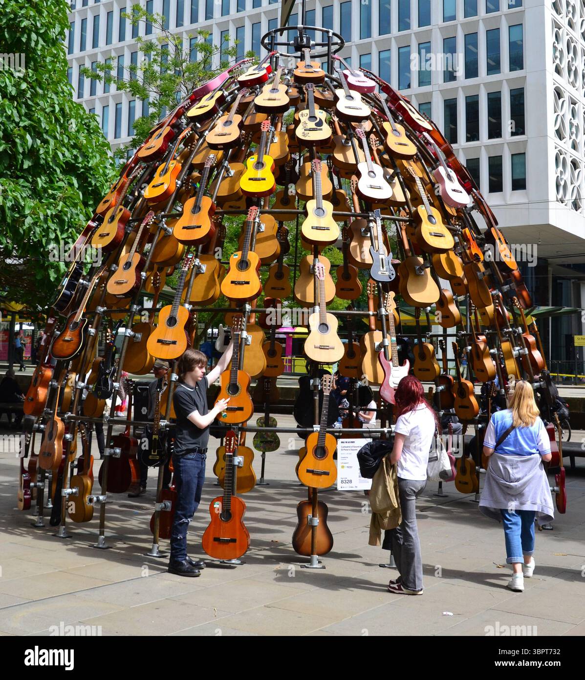 Quest'estate un percorso artistico che celebra la musica conquisterà il centro di Manchester, Regno Unito, con chitarre donate da famosi musicisti, nuove opere d'arte e murales della fermata del tram. Music for the Senses è prodotto dal produttore artistico Wild in Art e presenta più di 80 installazioni e opere d'arte diverse per onorare la fiorente scena musicale di Manchester. Il percorso è attivo dal 7 luglio al 31 agosto. Le installazioni includono questa di Lazerian, costruita con dozzine di chitarre acustiche recuperate in Piazza San Pietro. Foto Stock