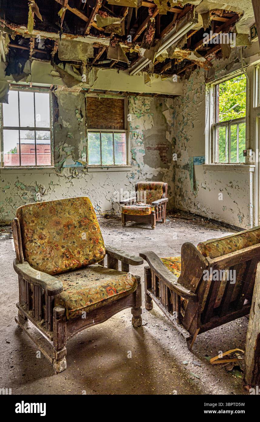 Sedie all'interno di un edificio abbandonato solitario con vernice sbucciante sulle pareti, Indiana USA Foto Stock