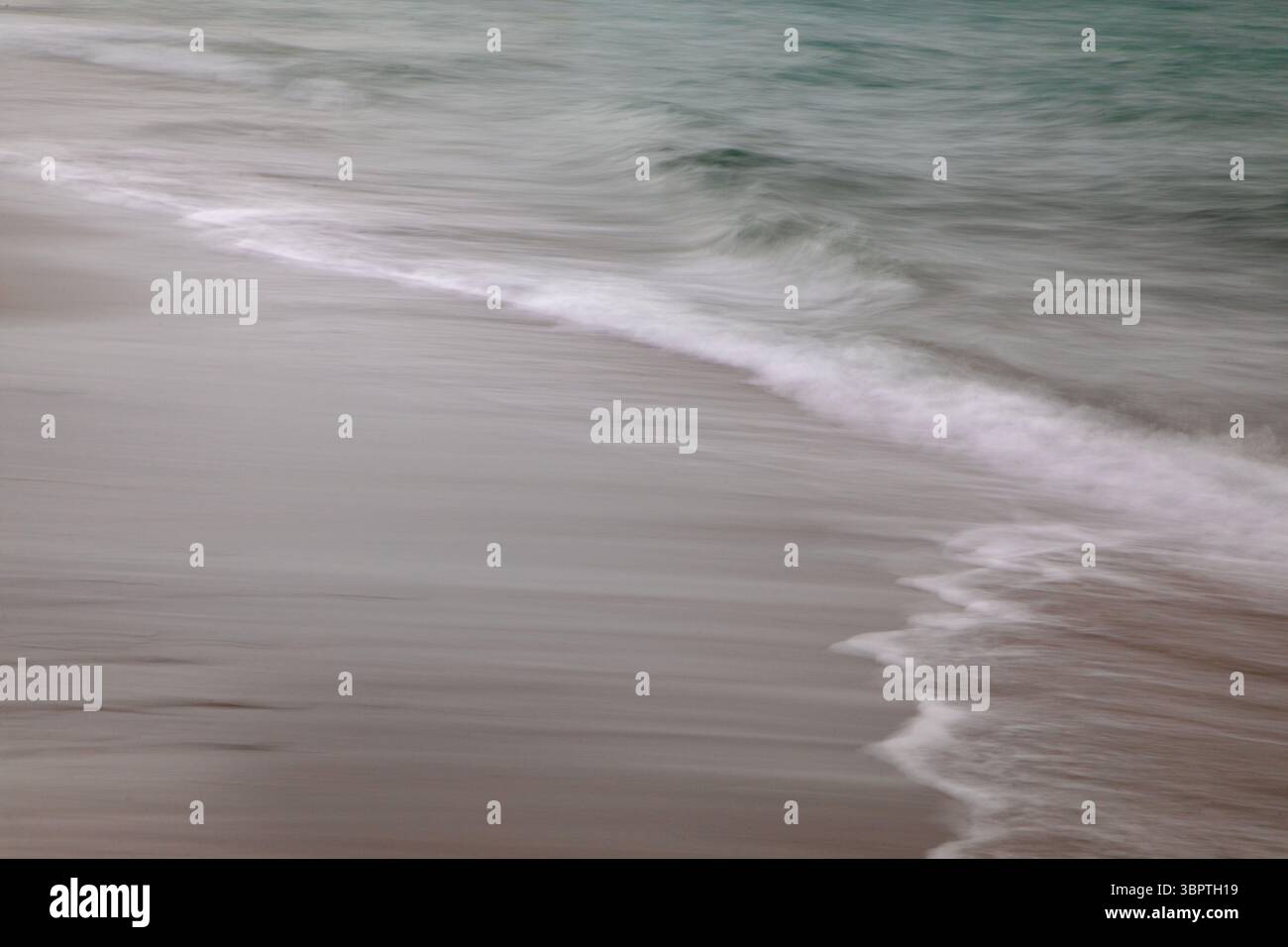 Quando il movimento della telecamera sfoca, le onde lungo la spiaggia, le onde bianche, l'oceano verde e verticale astratto Foto Stock