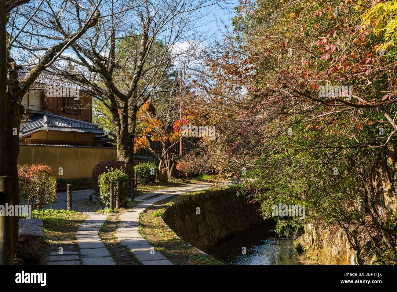 Il tranquillo sentiero dei filosofi (Tetsugaku no michi) a Kyoto, una passerella in pietra lungo un canale fiancheggiato da fogliame autunnale. Sakyo-ku, Kyoto, Giappone. Foto Stock