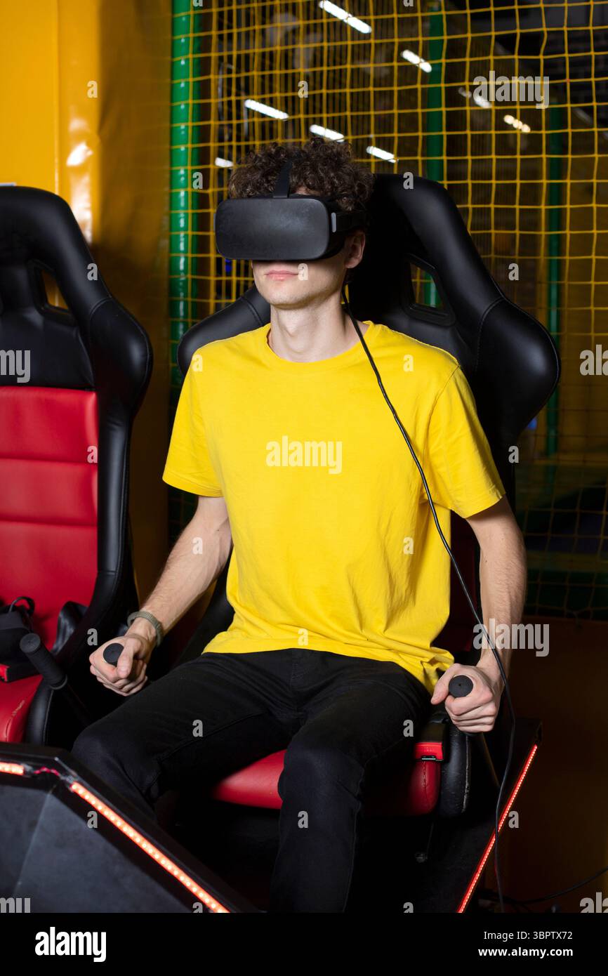 Un uomo guarda un video di gioco in occhiali per realtà virtuale. Giochi virtuali con visore VR. Foto Stock