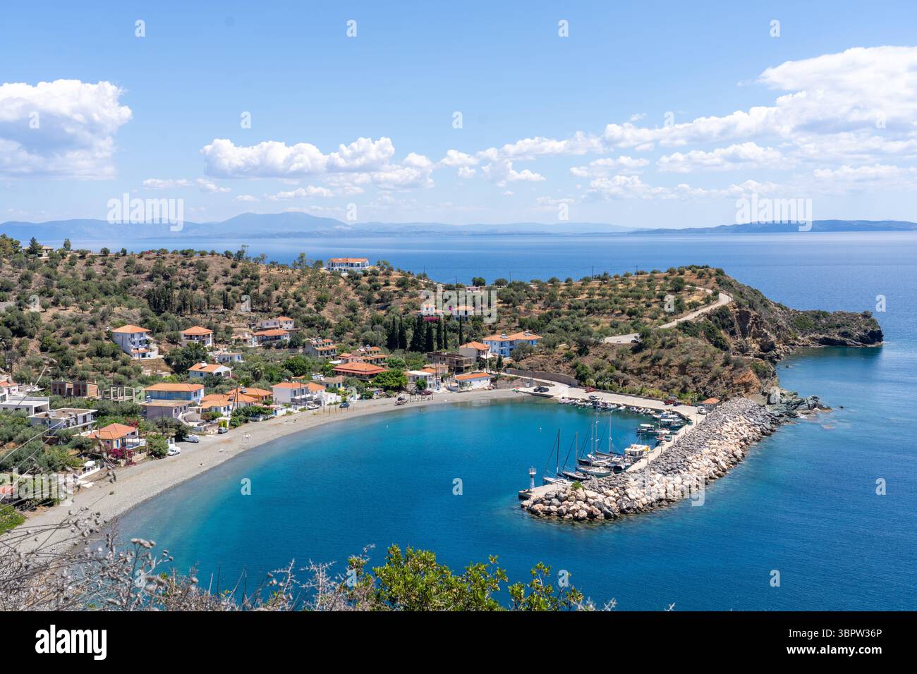 Porticciolo e case con acqua blu mediterranea a Sambatiki Grecia Foto Stock