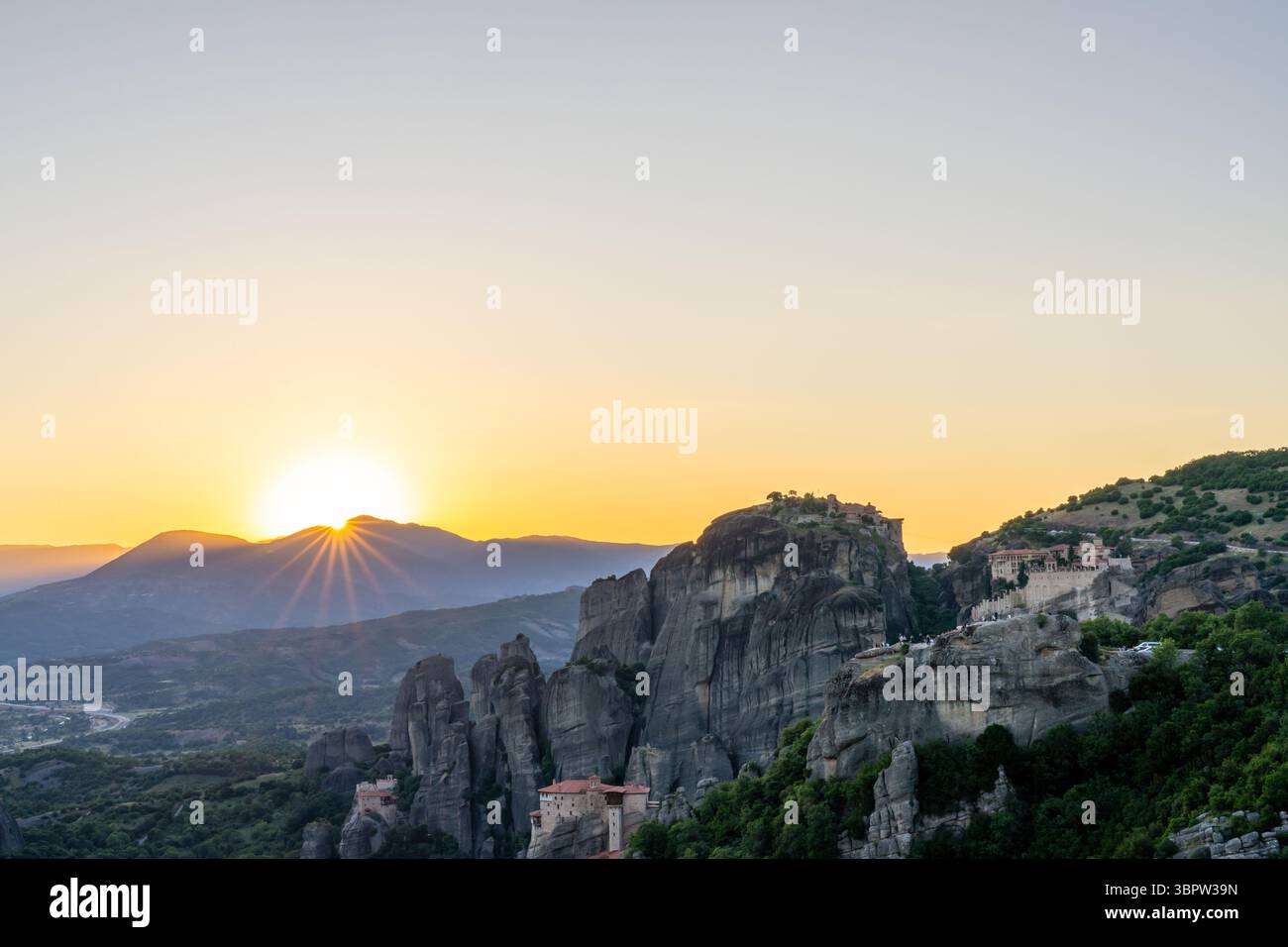 Tramonto a Meteora in Grecia con monasteri sulla cima delle guglie rocciose e un cielo perfetto Foto Stock