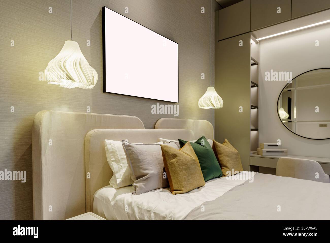 Interni moderni con due lampade a sospensione su un grande letto imbottito. Un telaio vuoto fornisce spazio per il mockup sulla parete. L'area lavandino è visibile. Foto Stock