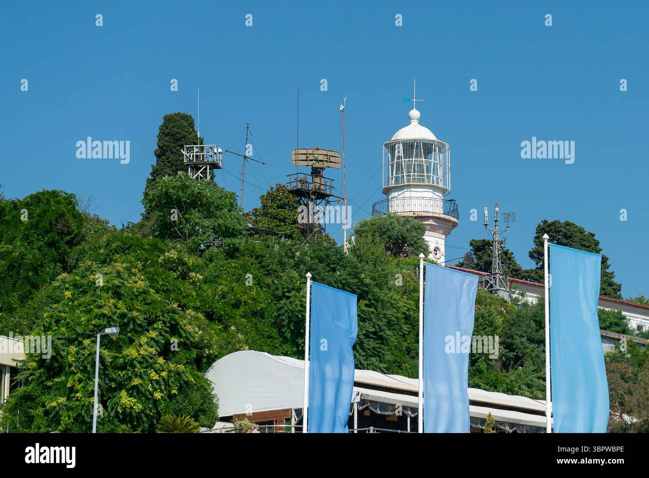 Faro marino e antenne radar marine su una collina. Sicurezza della navigazione marittima. Foto Stock