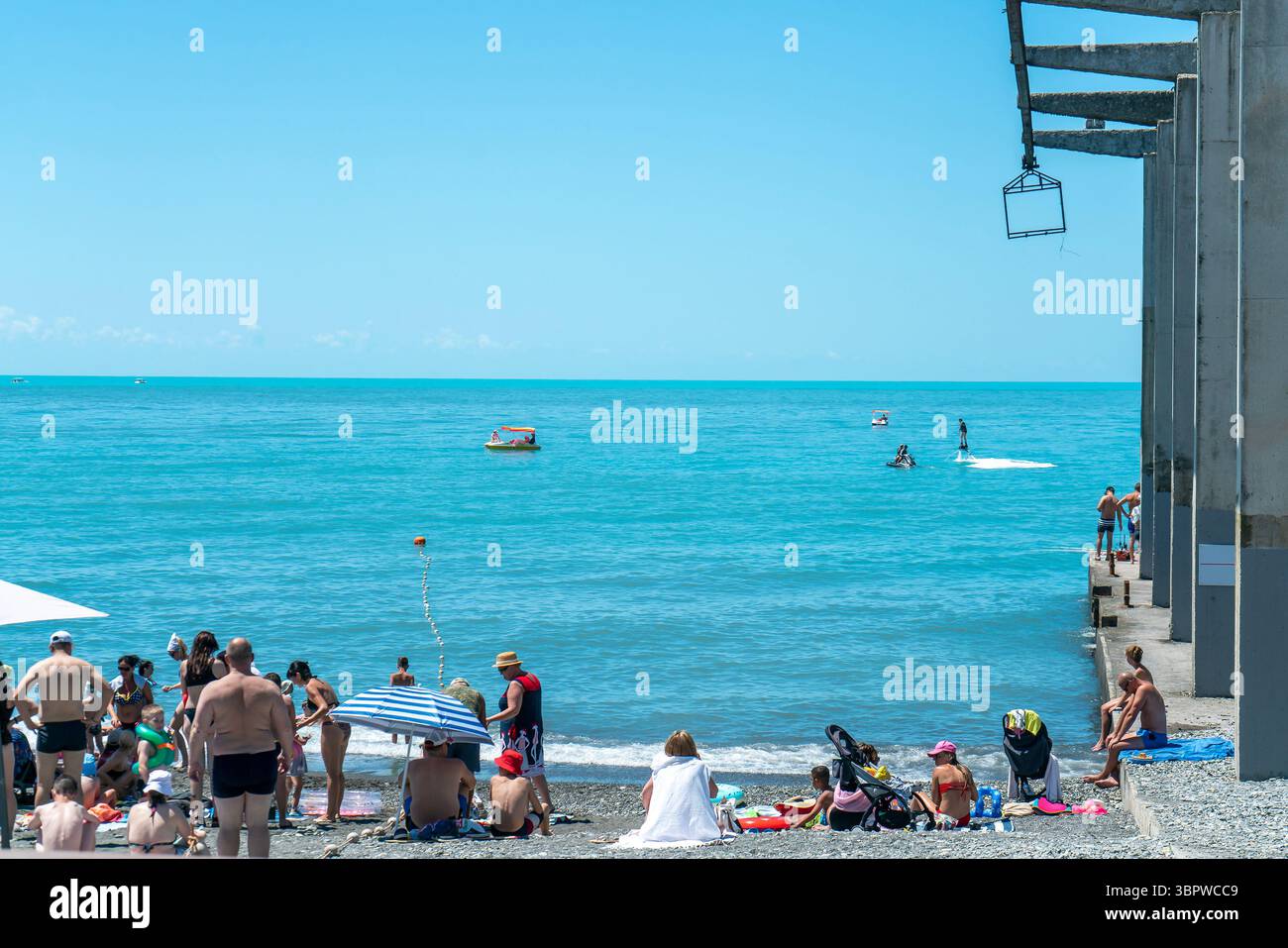 Sochi, Russia - 05 luglio 2022: Spiaggia cittadina in riva al mare con lettini e ombrelloni. Foto Stock
