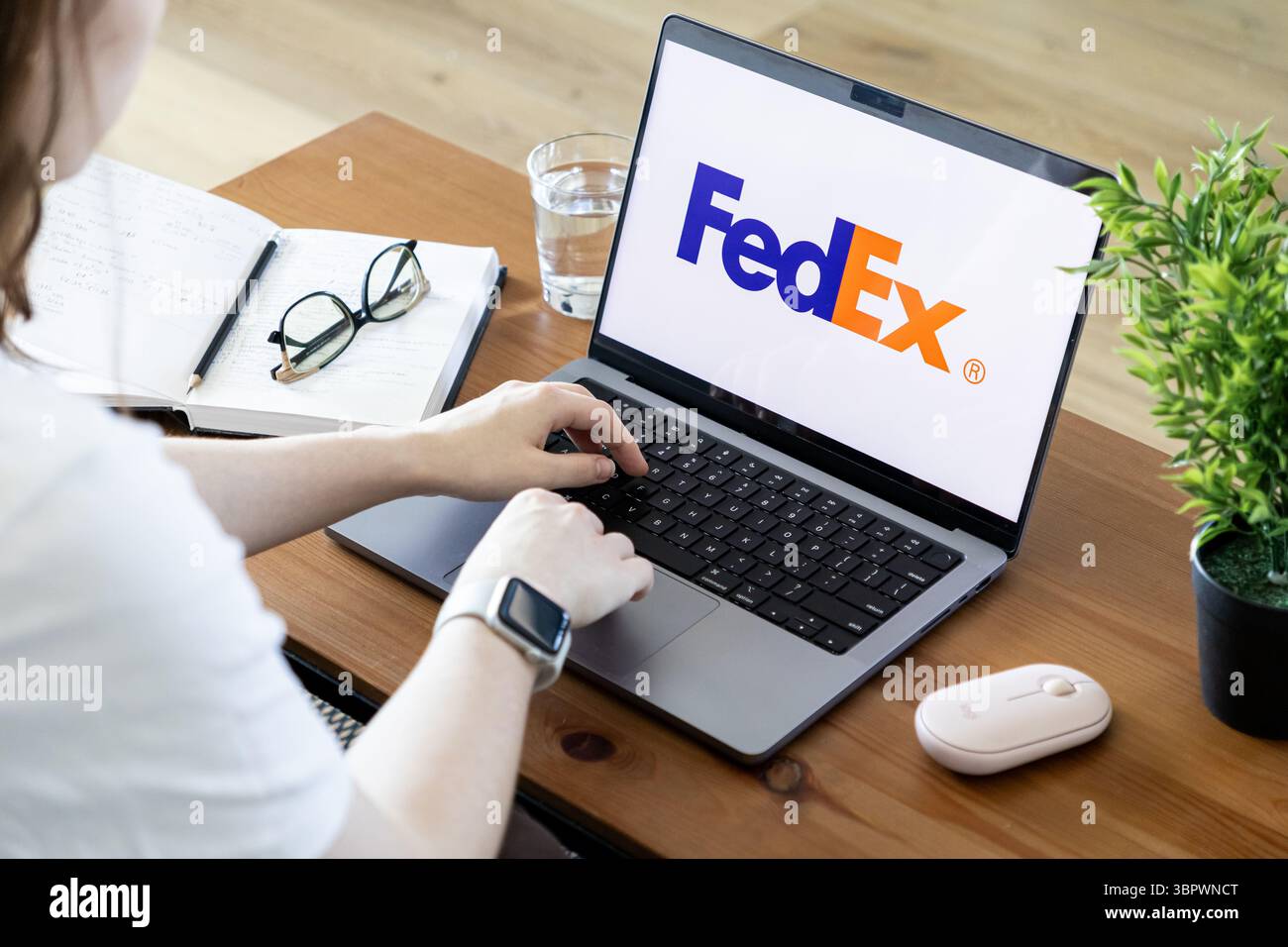 Poznan, Polonia - 15 giugno 2025: Primo piano di una persona che digita su un laptop che mostra il logo FedEx, simboleggiando l'efficienza della spedizione globale dei pacchi Foto Stock