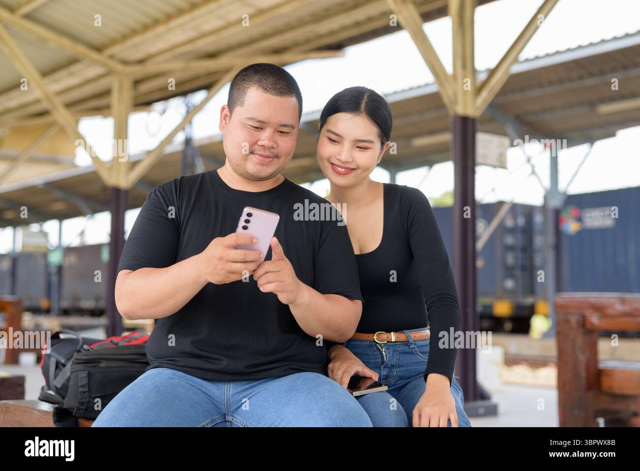 Giovane coppia asiatica in stazione ferroviaria insieme Foto Stock