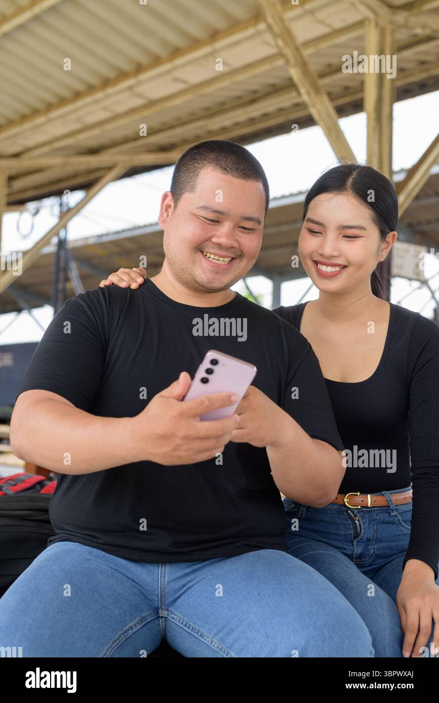 Giovane coppia asiatica in stazione ferroviaria insieme Foto Stock