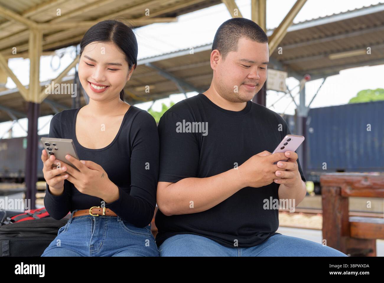 Giovane coppia asiatica in stazione ferroviaria insieme Foto Stock
