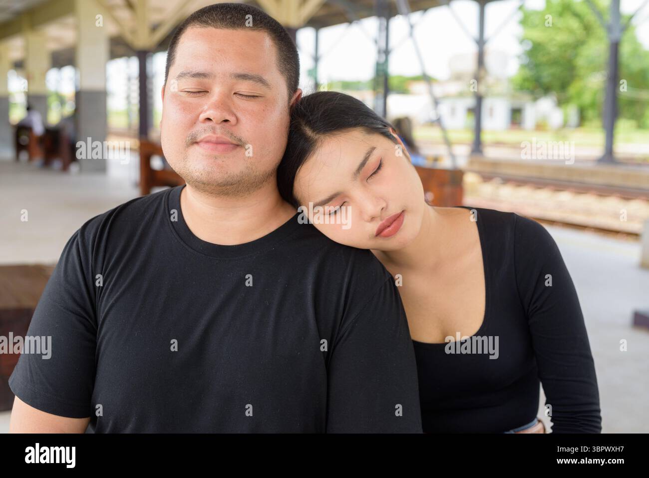 Giovane coppia asiatica in stazione ferroviaria insieme Foto Stock