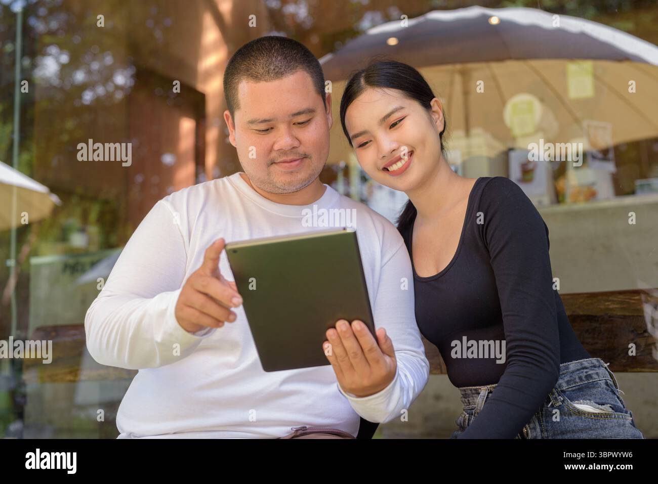 In caffetteria si può sedere in stile asiatico e utilizzare un tablet digitale Foto Stock